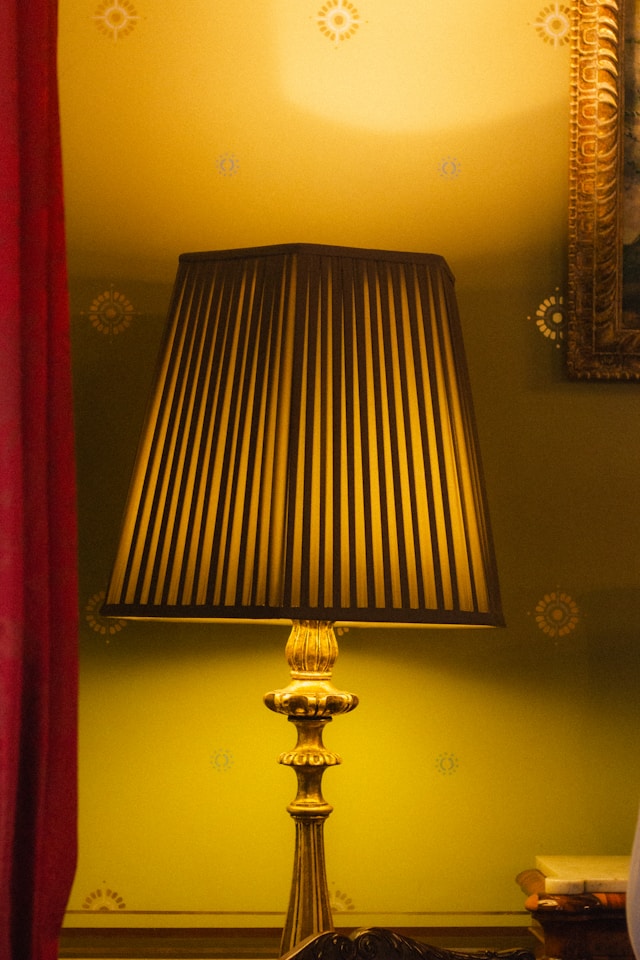 A vintage lamp with a pleated shade illuminating a room