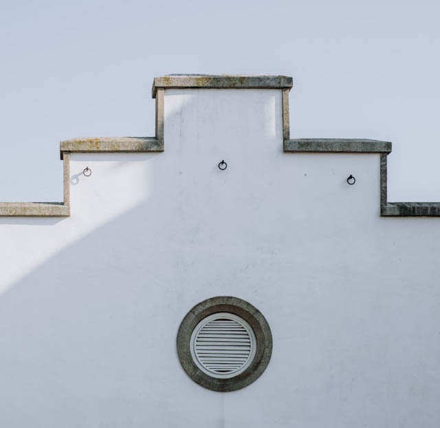 White building detail with round vent