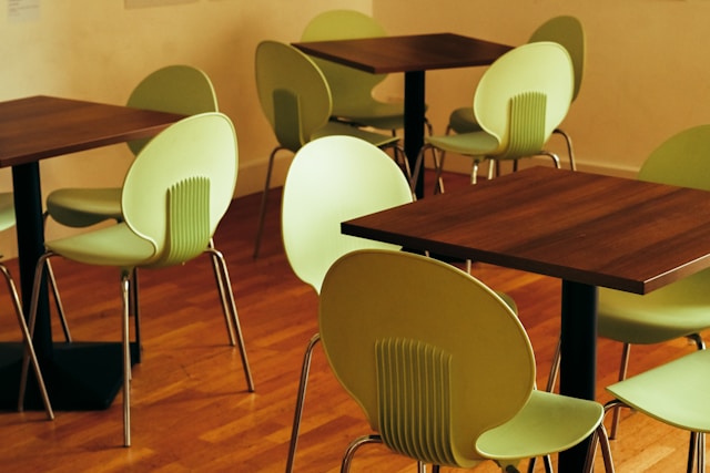 Green chairs and wooden tables in cafe